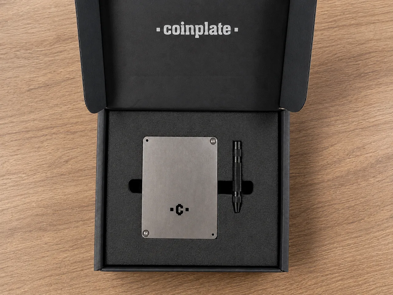 Open Coinplate Alpha presentation box with the stainless-steel backup plate and center-punch tool